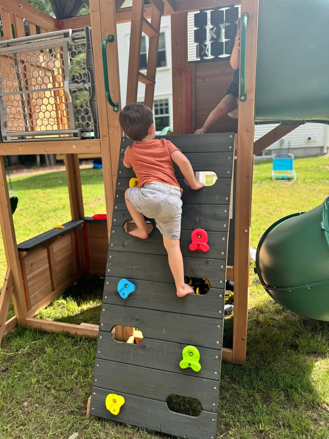 A child climbing the backyard rock wall