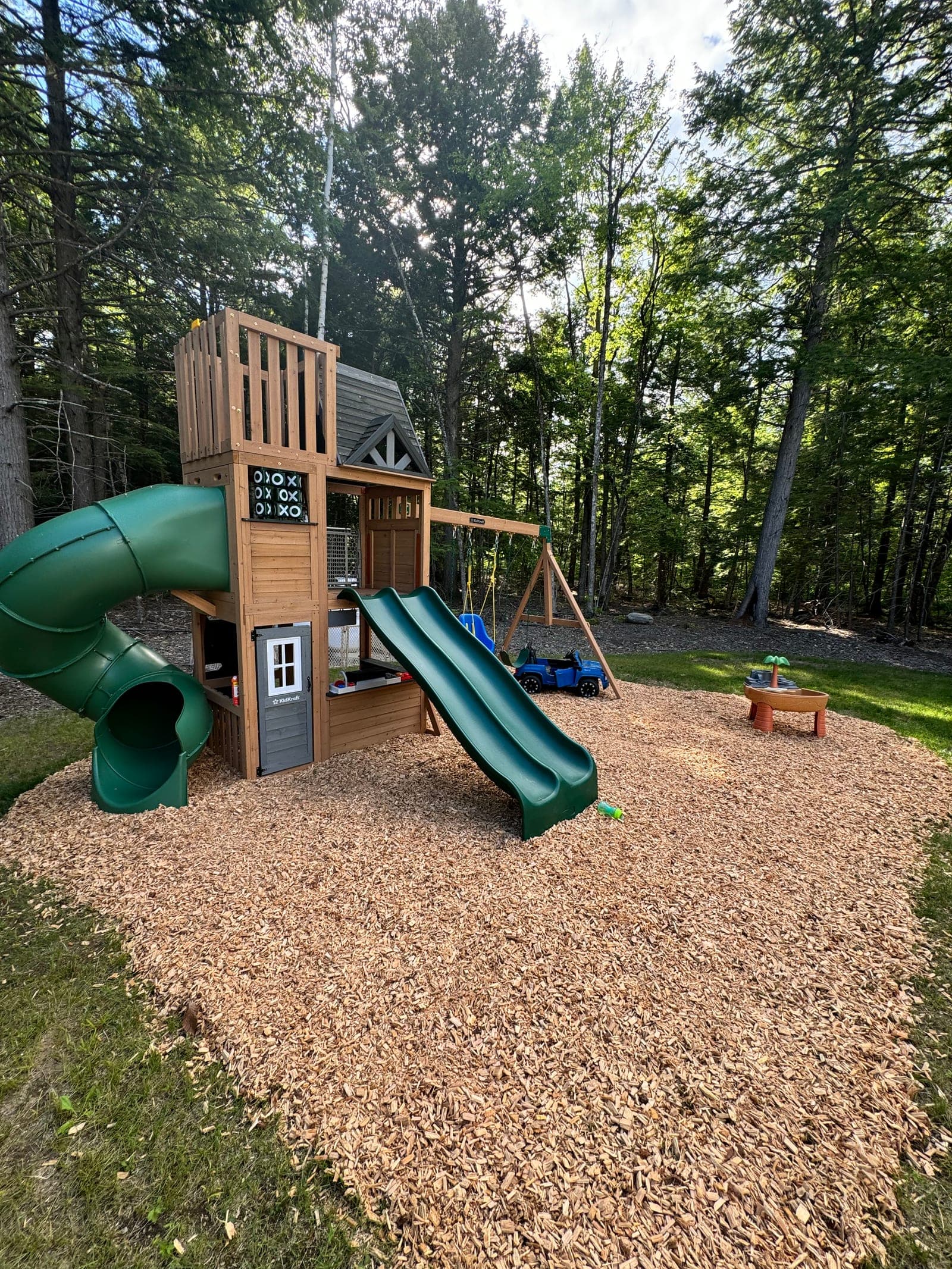 The natural-wood backyard play set in the pines